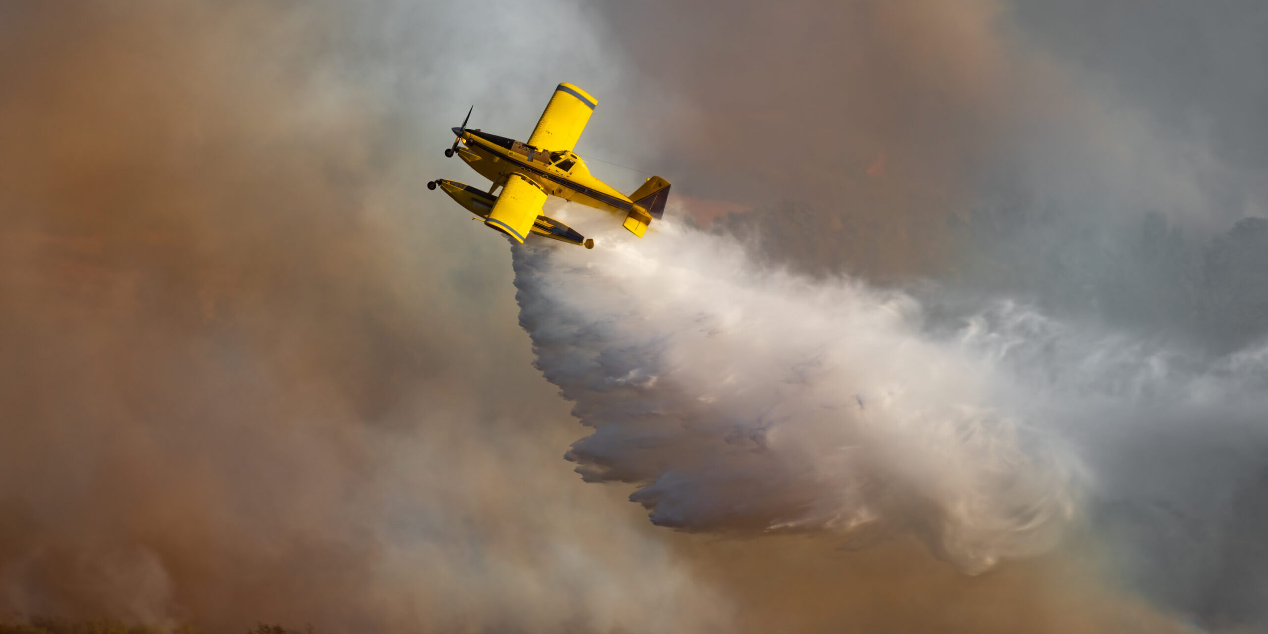 Spectacular hydroplane dropping water over the wild fire