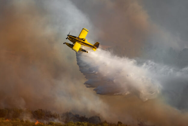 Spectacular hydroplane dropping water over the wild fire
